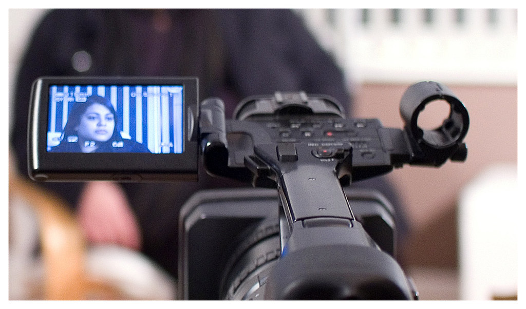 Camera operator setting up a video camera